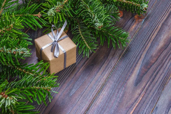 Новорічні фону з Різдвяний подарунок на дерев'яні фону з ялиці філій. Xmas та новим роком складу. Плоскі мирян, top погляд — стокове фото