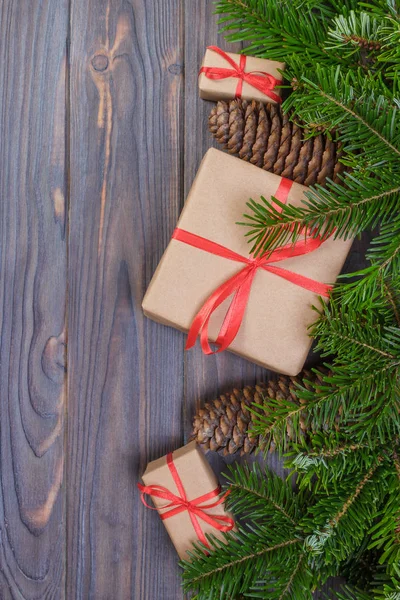 Noel ağacı dalı, süslemeleri ve hediye kutusu beyaz ahşap masa üzerinde