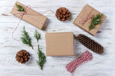 El hazırlanmış hediyeler, Noel arka plan üzerinde rustik ahşap masa sunar. Noel ve yeni yıl DIY ambalaj. Tatil dekorasyon konsepti. Genel gider, düz yatıyordu, en iyi görünümü