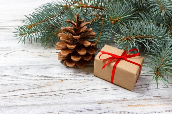 Regalos de Navidad o Año Nuevo envueltos en papel de color natural y decorados con trenzas tradicionales de Navidad y ramitas de abeto sobre un fondo blanco —  Fotos de Stock