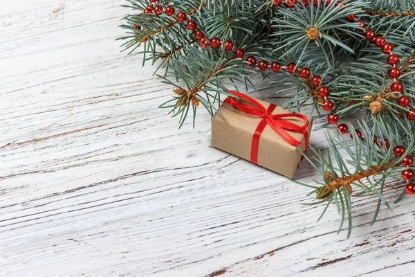 Weihnachts- oder Neujahrsgeschenke in naturfarbenes Papier gewickelt und mit traditionellem Weihnachtsgeflecht und Tannenzweigen auf weißem Hintergrund dekoriert — Stockfoto