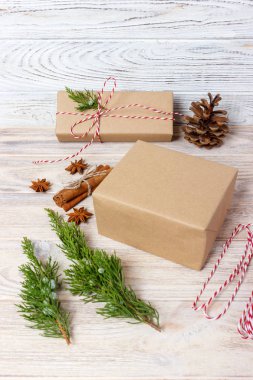 Yaratıcı hobi. Hediye. Saten kurdele ile şık gri kağıt modern Noel hediyesi ambalaj kutuları. Üstten Görünüm tablo köknar ağacı dalları, dekorasyon ile