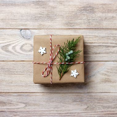 Gift box with red ribbon over white wooden background clipart
