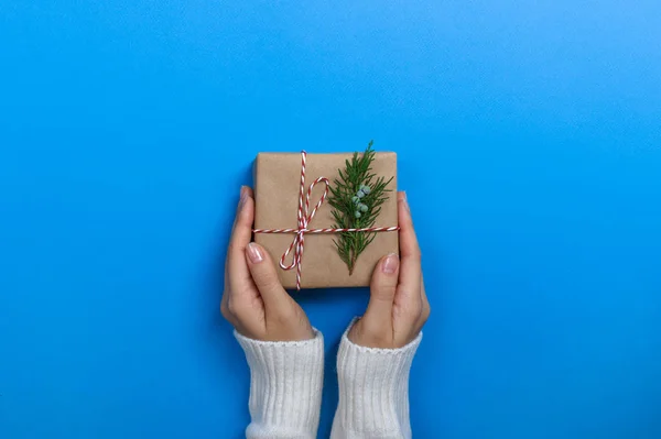 Vrouwelijke handen houden geschenkdoos op blauwe achtergrond — Stockfoto