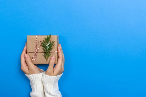 Mãos de mulher segurando uma caixa de presente de Natal. Presentes de Natal e Ano Novo. Feito à mão — Fotografia de Stock