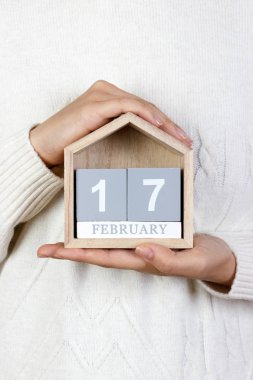 17 Şubat takvim. Kız ahşap bir takvim tutuyor. Doğal iyilik gün