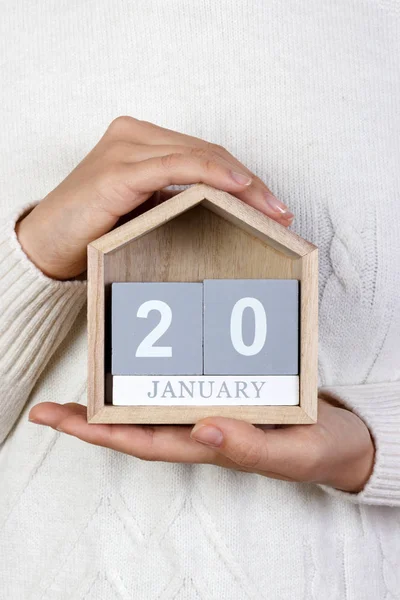 20 de enero en el calendario. la chica sostiene un calendario de madera. día de inauguración — Foto de Stock