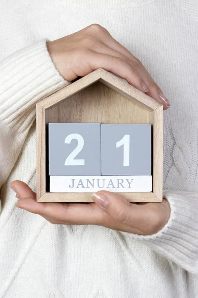 21 de enero en el calendario. la chica sostiene un calendario de madera. Día Internacional del Abrazo — Foto de Stock