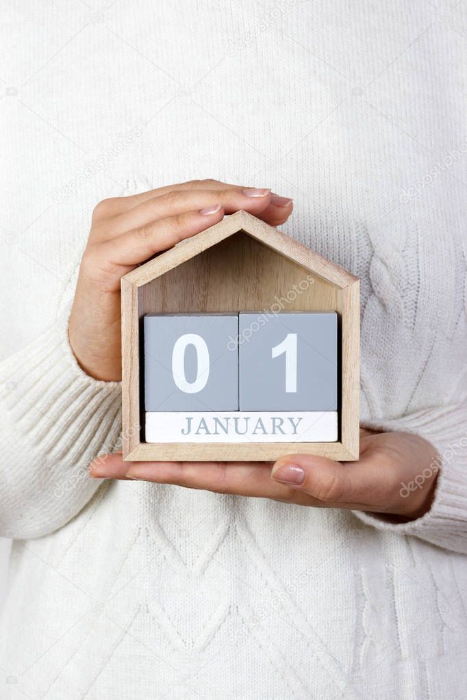 January 1 in the calendar. the girl is holding a wooden calendar. New Year. World Day of Peace. Feast of Mary