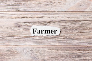 Kağıt üzerinde kelime çiftçi. kavram. Çiftçinin kelimelik bir ahşap arka plan
