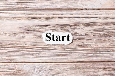 Kağıt üzerinde kelime başlangıcı. kavram. Başlangıç bir ahşap zemin üzerine sözleri