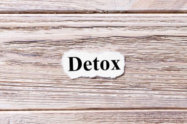 Detoks kelime kağıt üzerinde. kavram. Detoks kelimelik bir ahşap arka plan