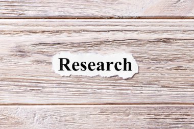 Araştırma kağıt üzerinde kelime. kavram. Ahşap arka plan üzerinde araştırma kelime