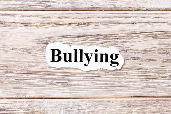 Bullying da palavra no papel. conceito. Palavras de bullying em um fundo de madeira — Fotografia de Stock