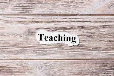 Kağıt üzerinde kelime öğretimi. kavram. Öğretim kelimelik bir ahşap arka plan