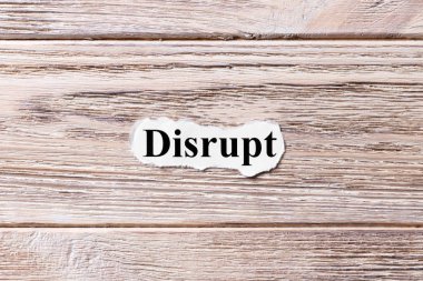 DISRUPT of the word on paper. concept. Words of DISRUPT on a wooden background clipart