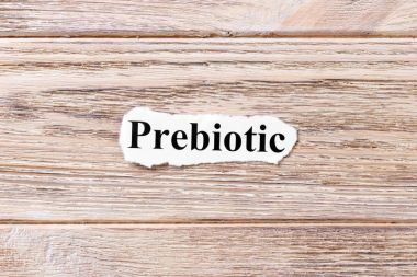 Kağıt üzerinde kelimenin Prebiyotik. kavram. Prebiotic kelimelerin ahşap arka plan üzerinde