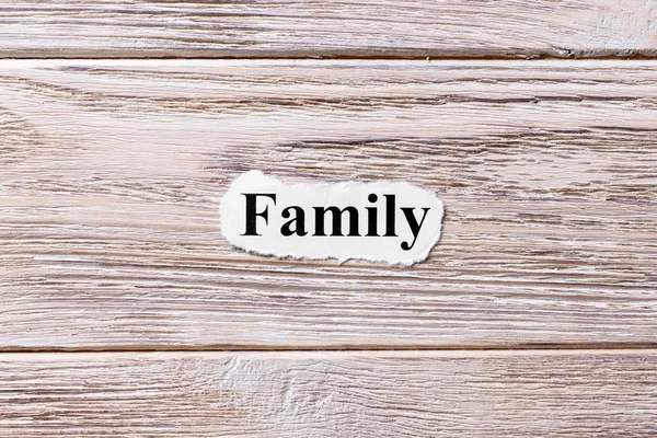紙の上の単語の家族。コンセプトです。木製の背景上の家族の言葉 — ストック写真
