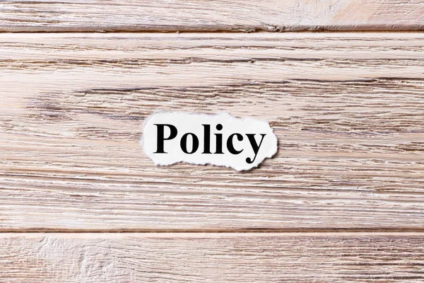 Policy of the word on paper. concept. Words of Policy on a wooden background