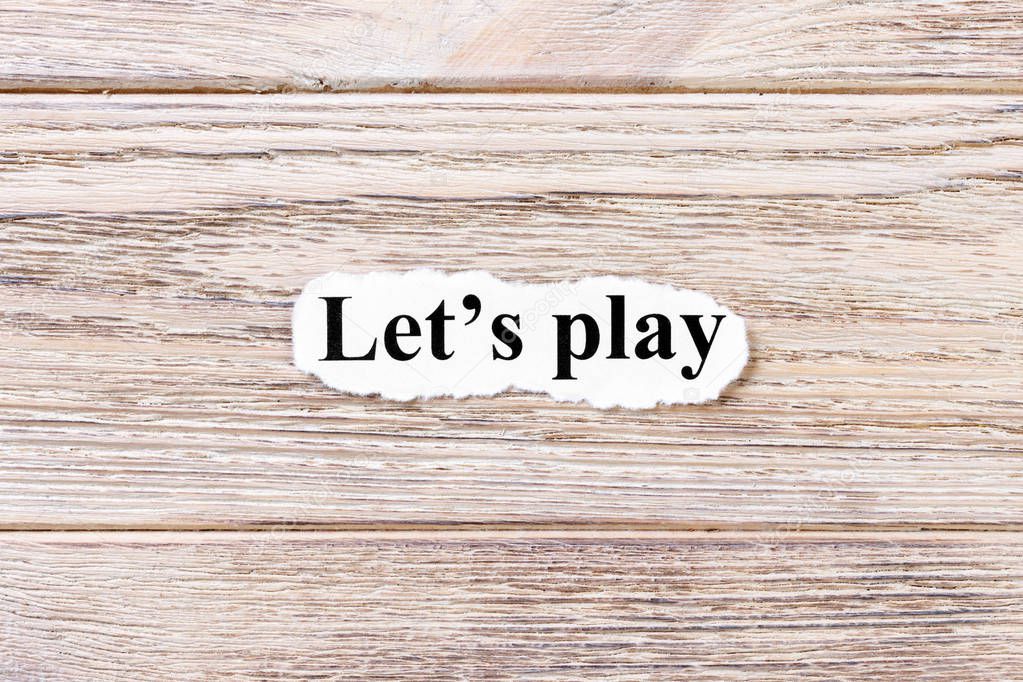 lets play of the word on paper. concept. Words of lets play on a wooden background