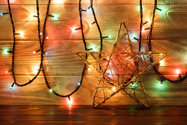 Винтажное рождественское украшение со звездами и огнями на деревянном столе — стоковое фото