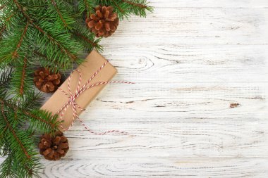 Wrapped Christmas gifts on dark rustic wooden table with pine cones and fir branches. With copy space for your text clipart