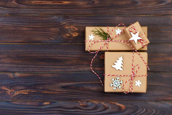 Tres cajas festivas en papel de cangrejo decorado con copos de nieve y estrella en la mesa de madera. Vista superior —  Fotos de Stock