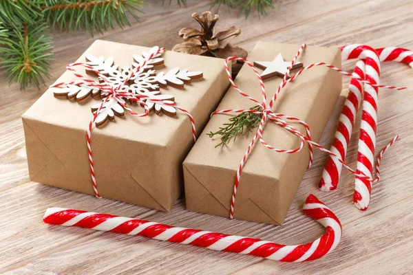 Гілка ялинки з різдвяною подарунковою коробкою та цукерками на дерев'яному фоні з пробілом для копіювання — стокове фото