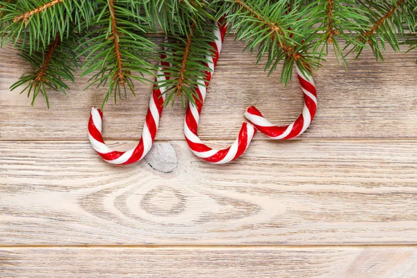 Rami di abete di Natale con canna da zucchero su sfondo di legno bianco rustico con spazio copia per il testo — Foto Stock