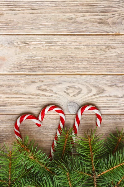 Ramo de árvore de Natal e cana-de-açúcar em uma mesa de madeira ou placa para fundo. Tema do ano novo. Espaço para texto — Fotografia de Stock