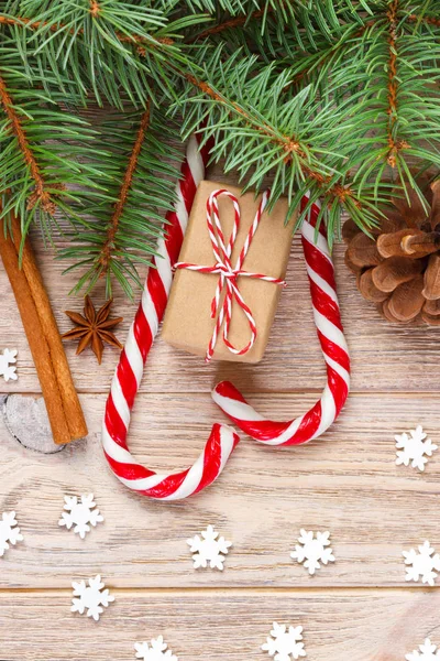 Regalo di Natale, bastoncini di zucchero e fiocchi di neve su sfondo di legno — Foto Stock
