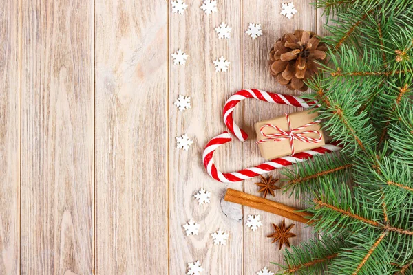 Χριστουγεννιάτικο φόντο με Χριστουγεννιάτικο δέντρο κλαδιά, κουκουνάρια, καραμέλα από ζαχαροκάλαμο γλυκά, δώρα, νιφάδα χιονιού και διακοσμήσεις, αντίγραφο χώρου — Φωτογραφία Αρχείου