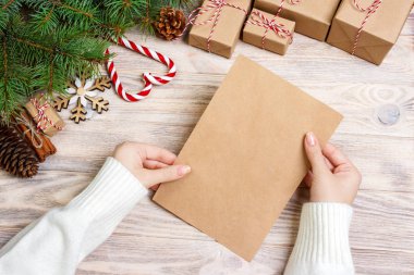 Eller neşeli Noel kartı ve zarf tutun. Noel dekorasyon arka plan. Düz yatıyordu, en iyi görünümü