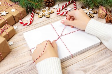 Birçok zarf ip ile bağladılar. Yakın çekim yukarıdan famale el ile zarf. Çam koniler ve Noel dekorasyonu eski ahşap tablo, Resepsiyon