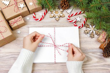 Birçok zarf ip ile bağladılar. Yakın çekim yukarıdan famale el ile zarf. Çam koniler ve Noel dekorasyonu eski ahşap tablo, Resepsiyon
