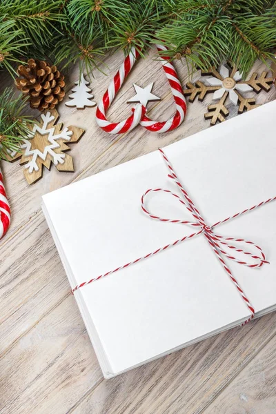 Zarf kağıt üzerinde Noel arka plan - köknar dalı, çam kozalakları, kırmızı kurdele, star ve tatlılar kalp boş levha ile. Senin metin için yer