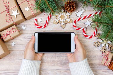 Smartphone ile boş ekran, trumpery çerçeve şenlikli kullanan kadın. Noel hediye arama, online alışveriş, mevsimlik indirimler ve satış konsepti