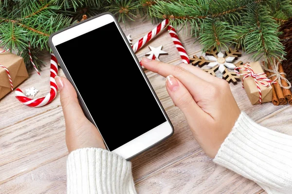 Kadın alıcı kopya alanı ile akıllı telefon ekranında sipariş yapar. Kış tatil satış. Noel online alışveriş