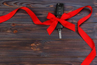 ahşap arka plan üzerinde renkli yay ile araba anahtarı
