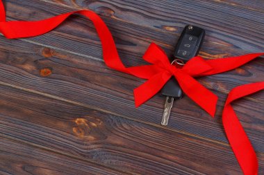ahşap arka plan üzerinde renkli yay ile araba anahtarı