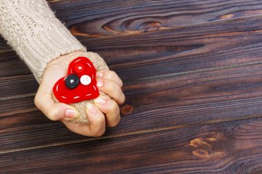 Ahşap arka plan üzerinde iki eliyle kalp krizi. Aşk kavramı ile boşaltmak