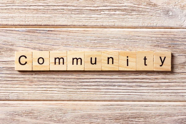 Слово спільноти, написане на дерев'яному блоці. Текст спільноти на столі, концепція — стокове фото