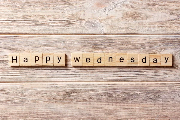 happy wednesday word written on wood block. happy wednesday text on table, concept