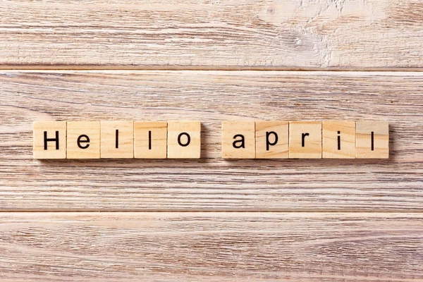 Olá, palavra de abril escrita em bloco de madeira. Olá texto de abril na mesa, conceito — Fotografia de Stock