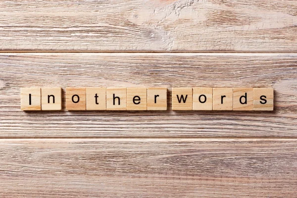 Em outras palavras, palavra escrita em bloco de madeira. em outras palavras, texto na tabela, conceito — Fotografia de Stock