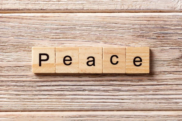Peace word written on wood block. Peace text on table, concept