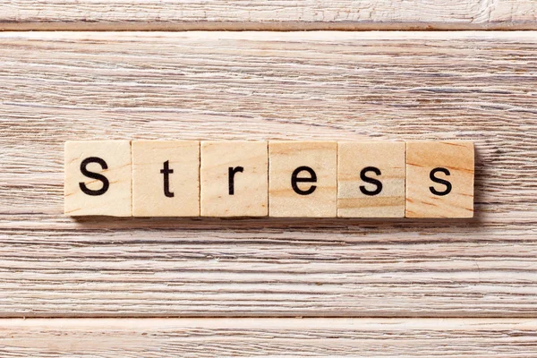 Стрес-слово, написане на дерев'яному блоці. Текст стресу на столі, концепція — стокове фото