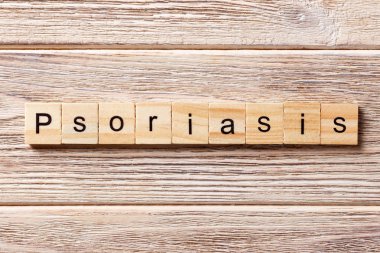 Tahta blokta sedef hastalığı kelimesi yazıyor. Masada sedef hastalığı metni, konsept