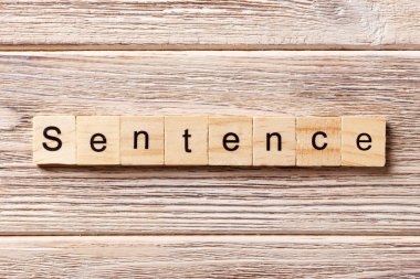 Tahta bloğa yazılmış bir cümle. Cümle metni masa üzerinde, konsept