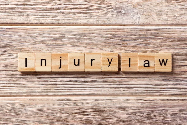 INJURY law word written on wood block. INJURY law text on table, concept — Stock Photo, Image